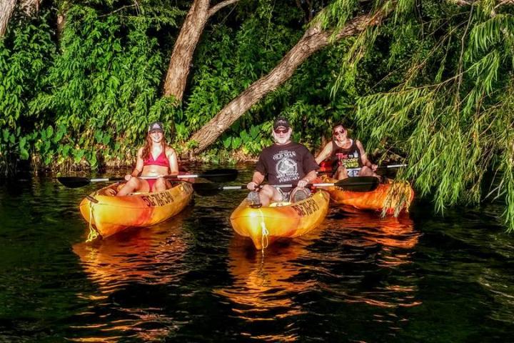 a group of people riding on the back of a boat in the water